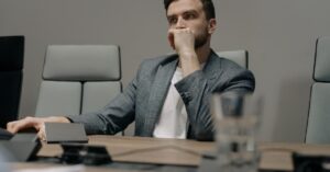 Líder pensativo em uma sala de reunião, refletindo sobre suas emoções — uma imagem que representa liderança resiliente, inteligência emocional e autoconsciência no trabalho.